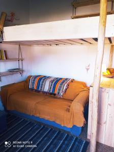 a bed in a room with a bunk bed at Cute Yellow house at the beach in Praia da Arrifana