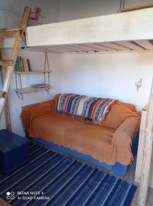 a bed in a room with a loft bed at Cute Yellow house at the beach in Praia da Arrifana