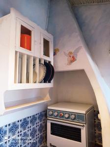 a small kitchen with a stove and cabinets at Cute Yellow house at the beach in Praia da Arrifana