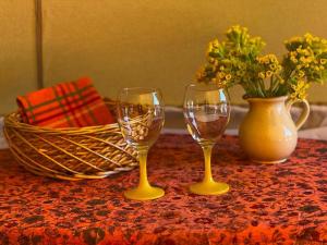 due bicchieri da vino e un vaso con fiori su un tavolo di Pädaste Aerga Sunset Glamping a Pädaste
