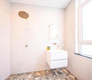 a white bathroom with a sink and a mirror at Newly build Utopia The Den Apartment 7-Minutes From Rotterdam City app2 in Schiedam