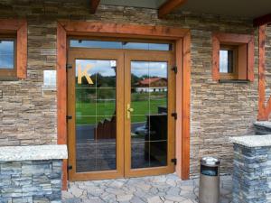 a wooden door on a house with a stone wall at Tatra Resort Apartmán in Veľká Lomnica +21 photos