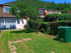 uma casa com uma lata de lixo verde no quintal em City House - up to 8 Persons em Kapfenberg