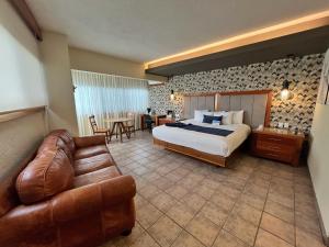 a hotel room with a bed and a couch at Comfort Inn Córdoba in Córdoba