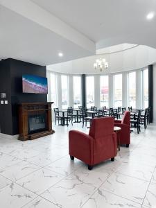 a large room with tables and chairs and a fireplace at Premier Inn & Suites - Downtown Hamilton in Hamilton