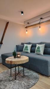 a blue couch in a living room with a table at Apartament u Gazdy przy Gondoli in Szczyrk