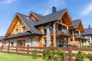 a log home with a black roof at APARTAMENT No 2 MOUNTAIN VIEV Sauna Priv z ogrodem okolice Zakopane Czorsztyn Kluszkowce in Kluszkowce