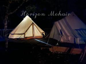 Saint-Projet的住宿－Horizon Mohair，两个白色帐篷在晚上点燃