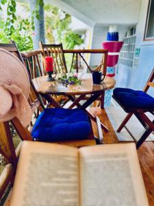 an open book sitting on a table with chairs at CASA MOSAICO in Puerto López +45 photos