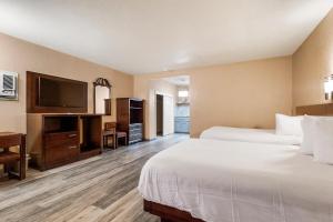 a hotel room with two beds and a flat screen tv at Country Inn Sonora in Sonora