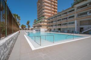 a swimming pool in front of a building at Playa Honda LA in Playa de las Americas