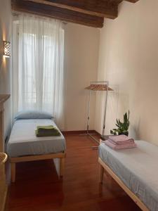 1 dormitorio con 2 camas y ventana en Loft Ponte Pietra, en Verona