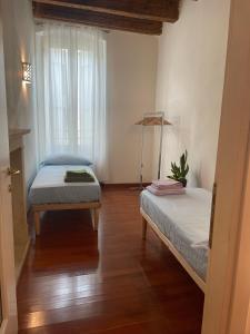 ヴェローナにあるLoft Ponte Pietraのベッドが2つと窓のある部屋