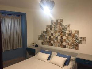 a bedroom with a bed and a light on the wall at Casa 13 in Montargil