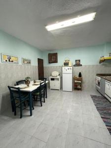 a kitchen with a table and chairs and a refrigerator at Casa 13 in Montargil