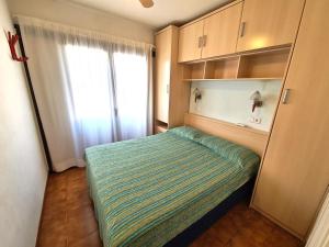 Habitación pequeña con cama y ventana en Appartement Sant Antoni, en Sant Antoni de Calonge