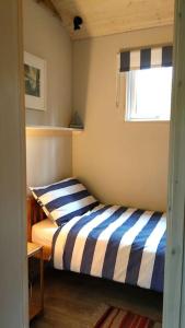 sypialnia z łóżkiem z niebieskimi i białymi paskami w obiekcie Secluded cosy cabin near town centre w mieście St Austell