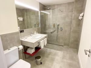 a bathroom with a sink and a shower at Apartamentos La Canal in Soto de la Marina