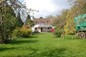 a large white house with a green yard at Secluded cosy cabin near town centre in St Austell