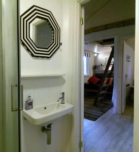 a bathroom with a sink and a mirror on the wall at Secluded cosy cabin near town centre in St Austell