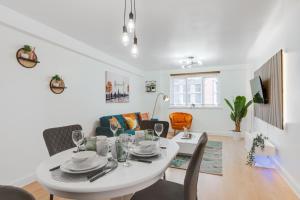 a dining room and living room with a white table and chairs at CEFAS Apartments Manchester - Free Parking - City Centre in Manchester