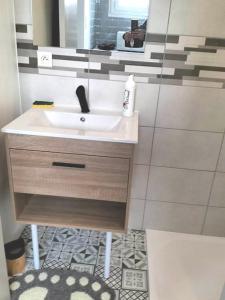 a bathroom with a sink and a mirror at Appartement avec balcon et parking privé in Roanne