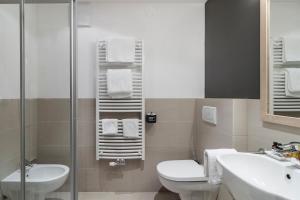 e bagno con servizi igienici, lavandino e doccia. di Hotel Christof a Monguelfo