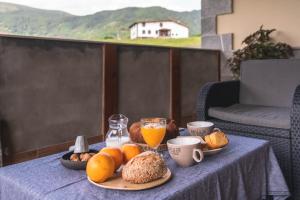 a table with a plate of food and cups of orange juice at LAIZARRONDO in Arantza
