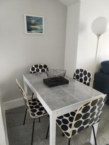 un tavolo bianco con sedie e una lampada in una stanza di Rhodri Apartment with Sea Views and Sun Terrace a Trearddur