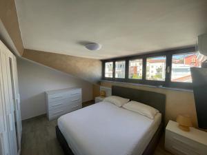 1 dormitorio con 1 cama blanca y 2 ventanas en GG Apartment, en Agropoli