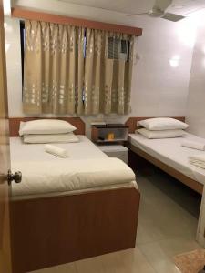 a bedroom with two beds and a window with curtains at 香港太阳宾馆 in Hong Kong