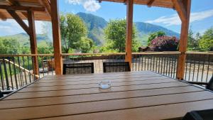 - une table en bois sur une terrasse avec vue sur les montagnes dans l'établissement Hámor Panzió, à Rimetea