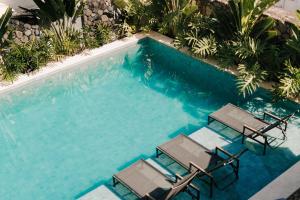 a swimming pool with two lounge chairs and a swimming pool at Pousada Zama in Camburi