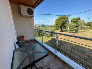 balcón con silla y vistas a un campo en Vaso's Paradise, en Eretria