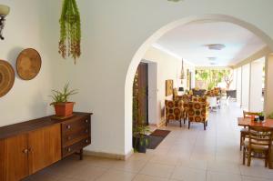 een woonkamer met een boog en een eetkamer bij BOUGAINVILLA Boutique Hotel & Restaurant in Lubumbashi