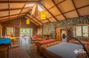 a bedroom with a bed and a living room at Snow Heights Lodges in Kasese