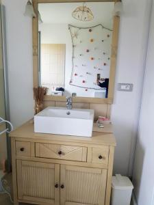 ein Bad mit einem Waschbecken und einem Spiegel in der Unterkunft Batellu in Ventiseri