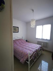 1 Schlafzimmer mit einem Bett mit einer lila Decke und 2 Fenstern in der Unterkunft Batellu in Ventiseri