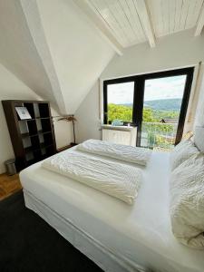 two beds in a bedroom with a large window at Heidrun's Home in Altendiez