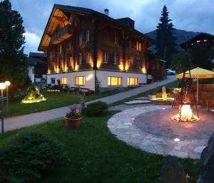 a large building with a fire patio in front of it at Casa Larisch in Sedrun