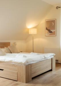 1 dormitorio con 1 cama grande con sábanas blancas en Dom nad jeziorem, przy lesie, en Czluchów