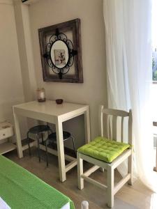 een kamer met een tafel, 2 stoelen en een spiegel bij Μελίτατα 19 in Rethimnon