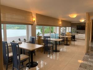 a restaurant with tables and chairs and a view of the water at Casa Dani in Colibiţa +47 photos