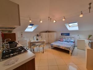 a kitchen with a bed and a table in a room at La Mansarda di Noi2 in Spotorno