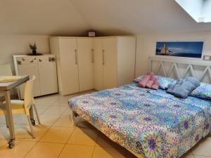 a bedroom with a bed and a table and cabinets at La Mansarda di Noi2 in Spotorno