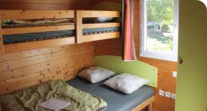 sypialnia z łóżkiem piętrowym w drewnianym domku w obiekcie Camping Onlycamp Pierre & Sources w mieście Volvic