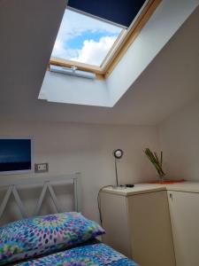 a bedroom with a skylight and a bed at La Mansarda di Noi2 in Spotorno