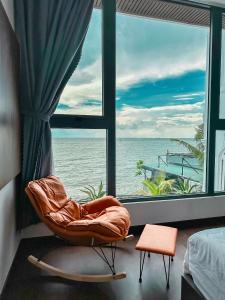 Habitación con silla frente a una ventana en The Palm Villa 24 Luxury ( 6 Bedroom , Karaoke, Bi-da ) en Vung Tau