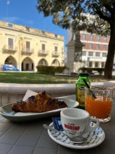 een tafel met een bord eten en een kopje koffie bij Il Cavalliere Bed & breakfast in Barletta