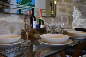 een tafel met kommen en wijnglazen erop bij VILLA MOST Tisno in Tisno
